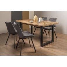 Indus Rustic Oak 4-6 Seater Dining Table with Peppercorn Legs & 4 Fontana Grey Velvet Fabric Chairs with Grey Hand Brushing on Black Powder Coated Legs