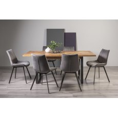 Indus Rustic Oak 6-8 Seater Dining Table with Peppercorn Legs & 6 Fontana Grey Velvet Fabric Chairs with Grey Hand Brushing on Black Powder Coated Legs
