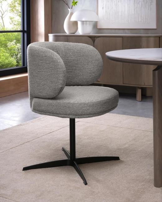 The Marcel dining chair pairs a curved, upholstered seat with a black pedestal and smooth swivel func...